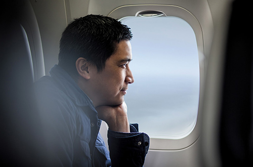 Man staring out the airplane window on a business trip