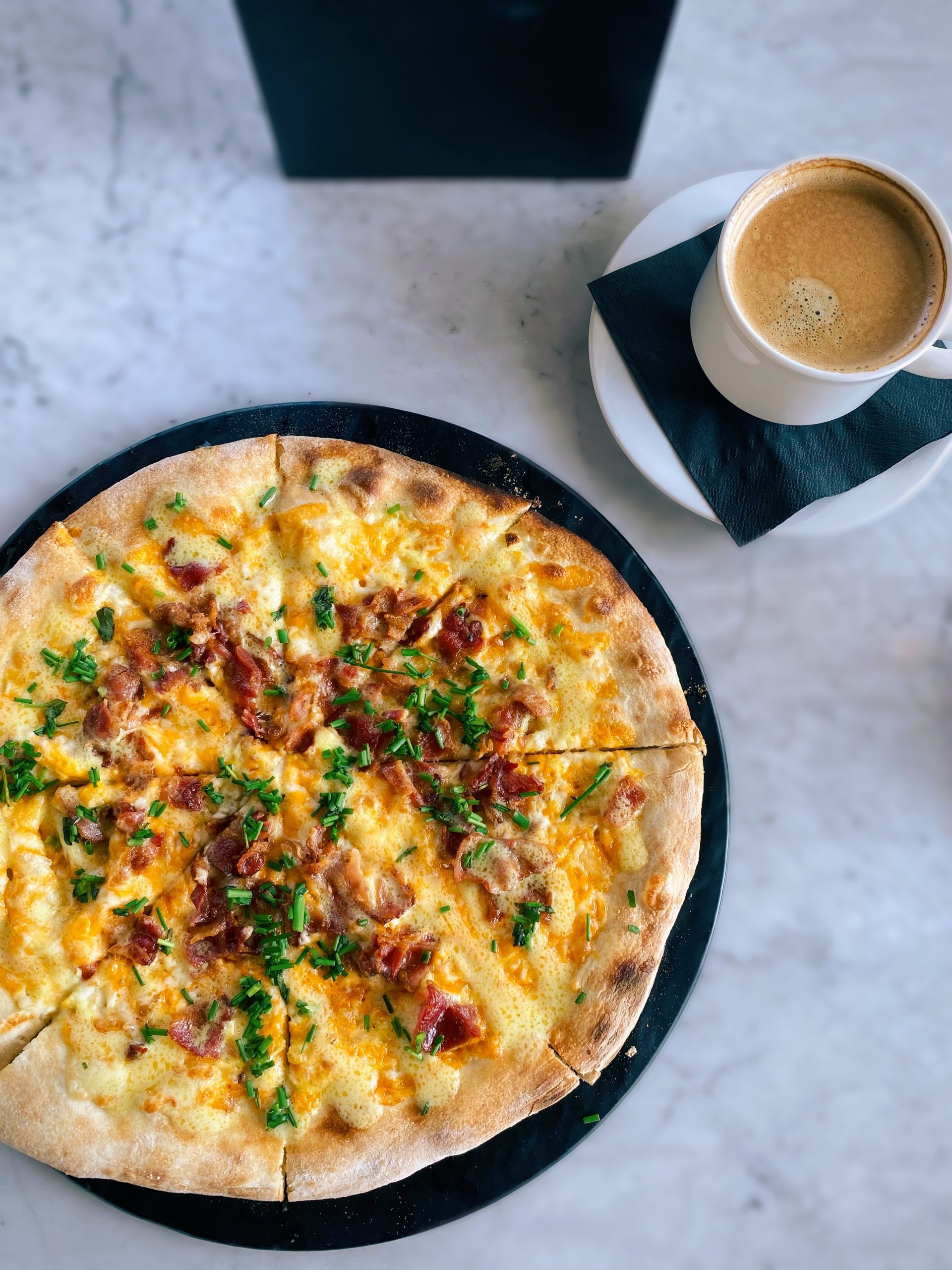 A flatbread and a cup of coffee