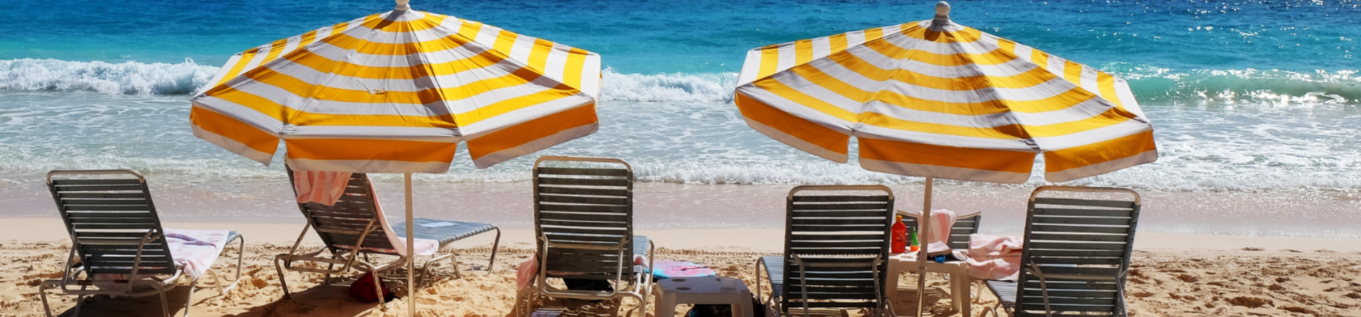 Deux parasols sur la plage au bord de l'eau